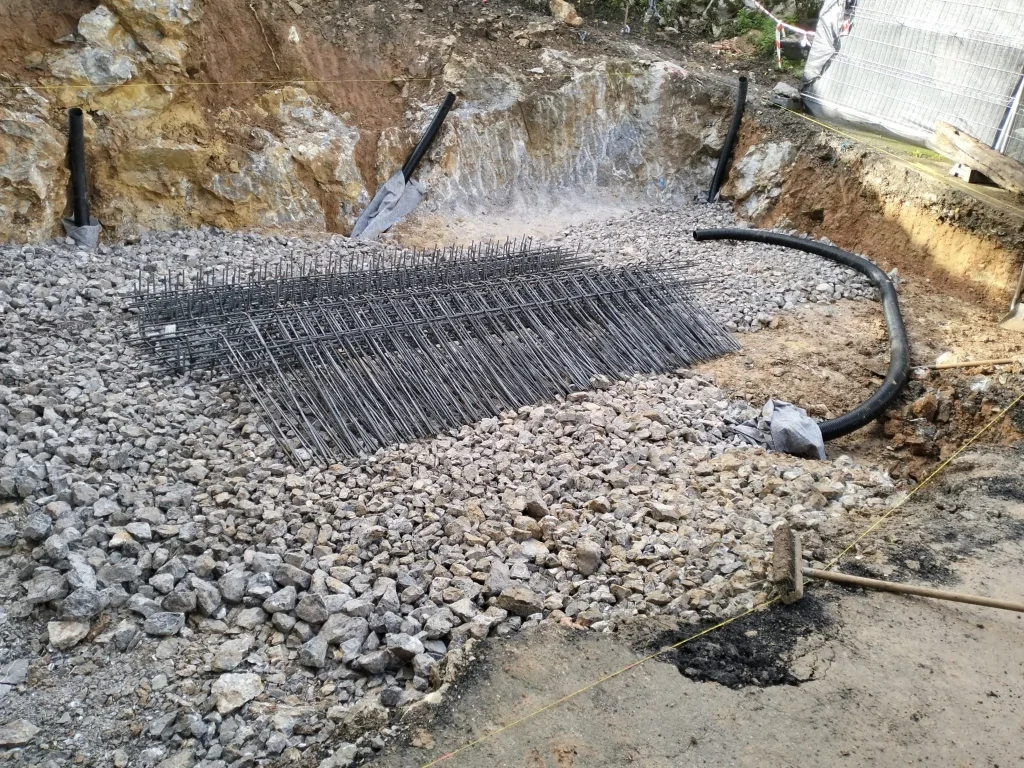 Excavación en roca con encachado de grava y drenaje para la cimentación