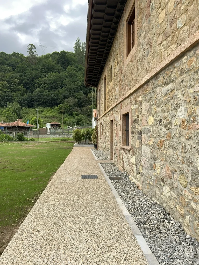 Camino perimetral de árido junto al muro de mampostería